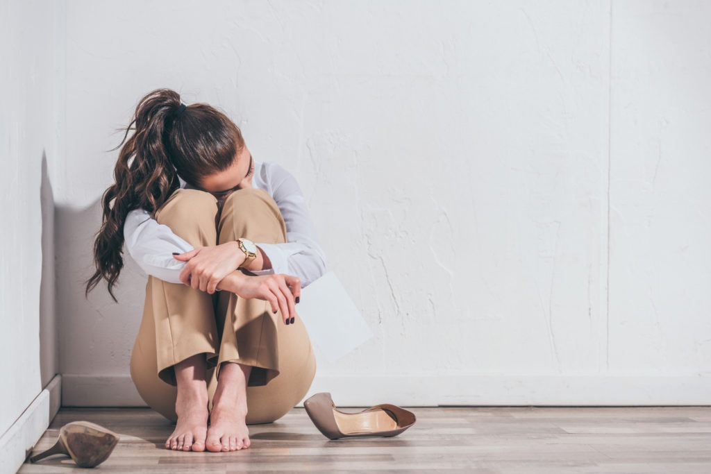 Woman crying on the floor after miscarriage