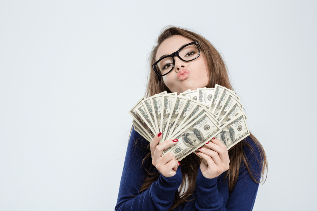 Woman holding money. She is using money affirmations to break through her money blocks.