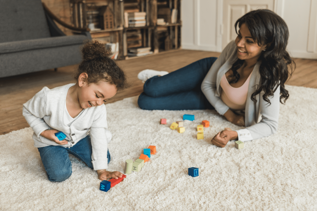 Girl playing on floor, mom wondering: "Are working moms happier?"