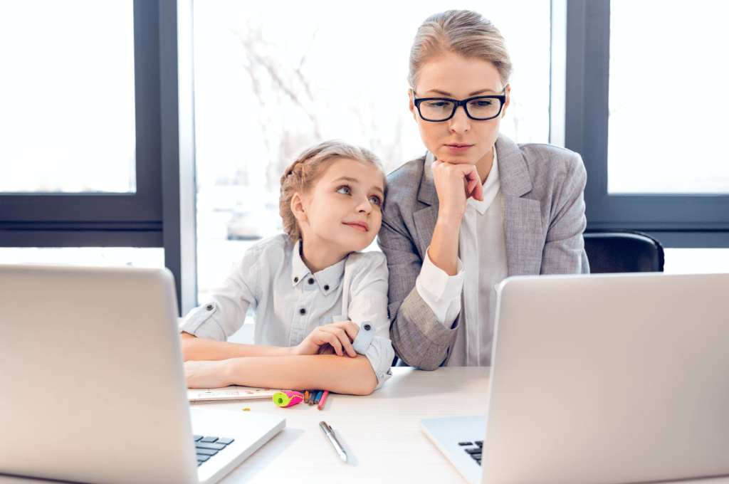 Work at home mom on the computer with her daughter by her side.