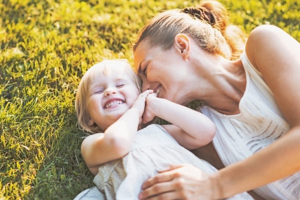 INFJ mom is cuddling with her toddler in the grass