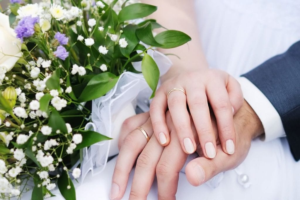 Woman and Man's hands wearing just wedding bands without engagement ring. Yes, it's okay for a woman to just wear a wedding band!