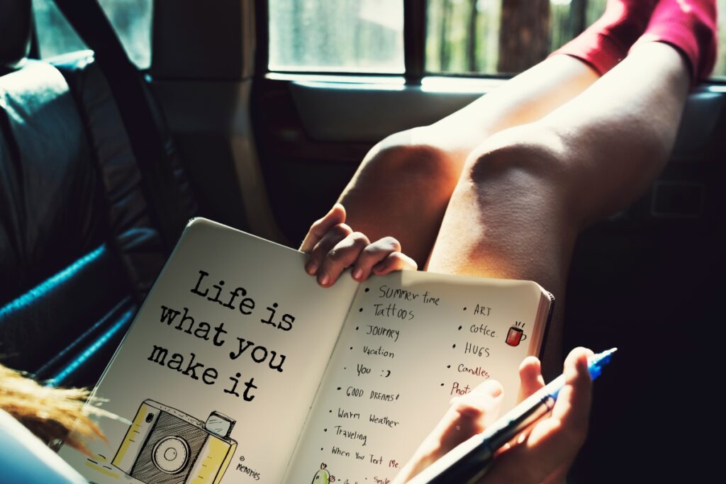 Woman writing powerful words in her journal in a car