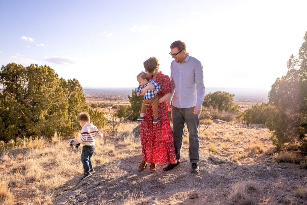 Parents and baby watch toddler walking in the desert. Jennifer Warren Family Photography.