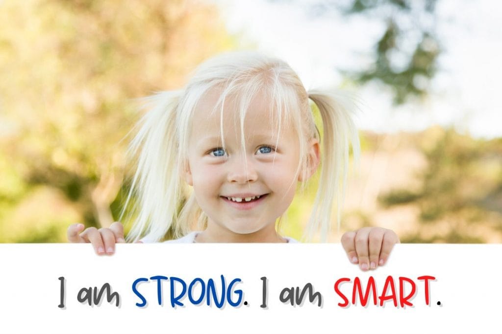 Girl holding a large card of Affirmation Cards for Kids