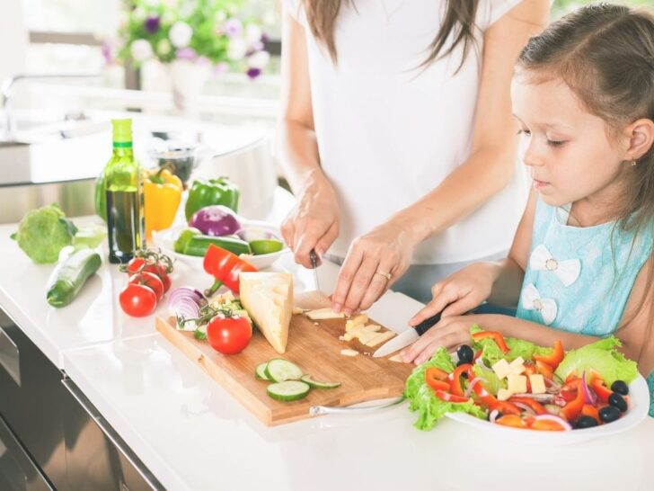 Young daughter helping meal planning strategies and meal prep with her mom.