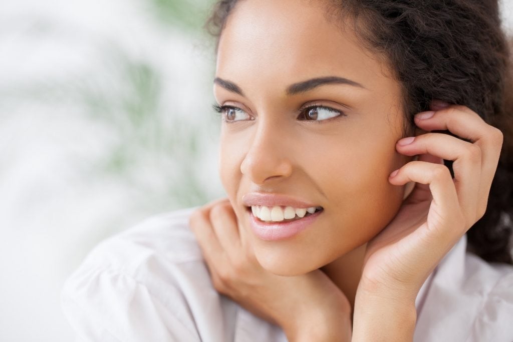 Woman using Arbonne Skin Elixir for beautiful skin