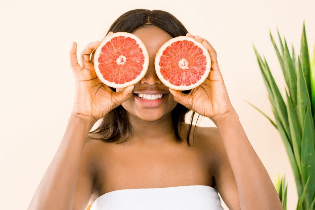 Woman with grapefruits enjoying the amazing benefits of self care