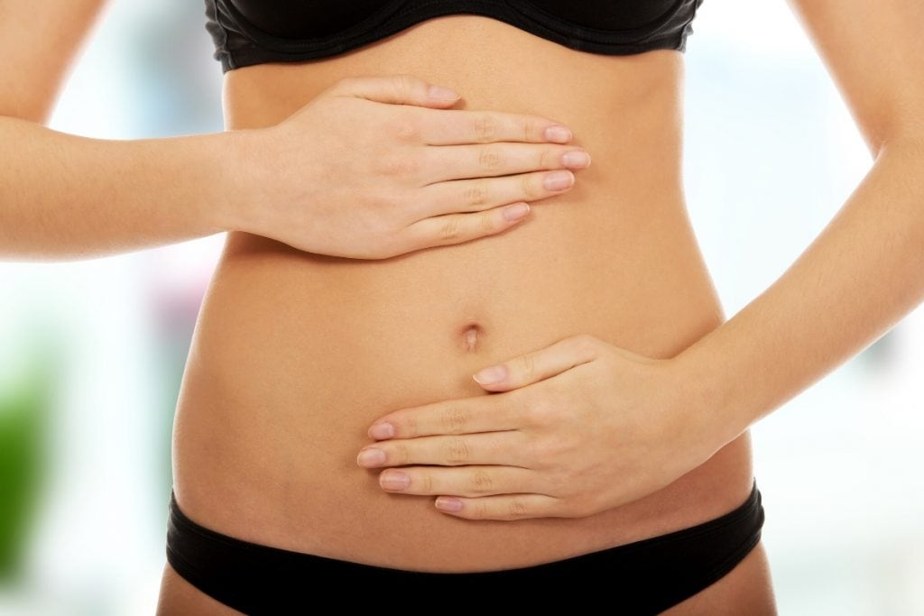 Woman holding belly after using the Arbonne Essentials 7-day Body Cleanse.