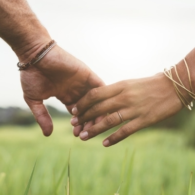 Close up on woman's and man's hands, holding gently