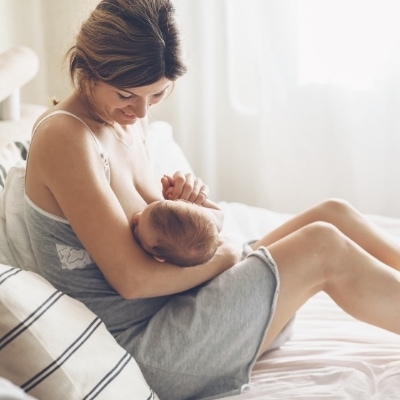 Postpartum woman is breastfeeding her baby