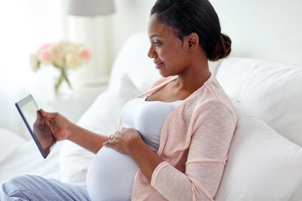 Pregnant woman looking at the best printable birth affirmation cards online.