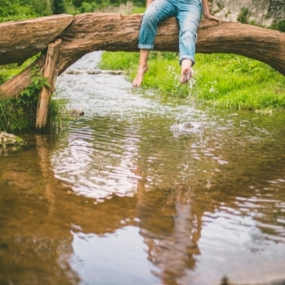 Woman kicking water in a stream