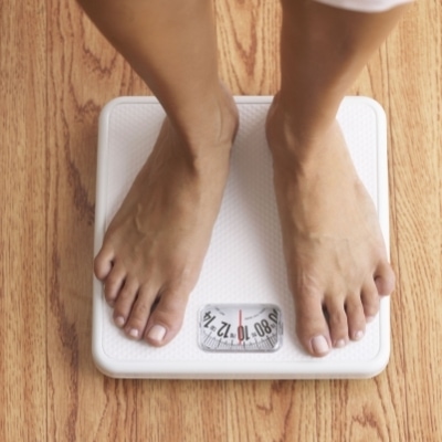 Woman weighing herself on a scale