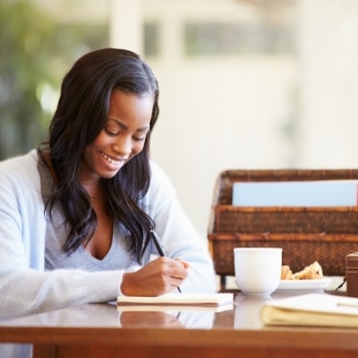 Woman writing in her journal about what she is grateful for