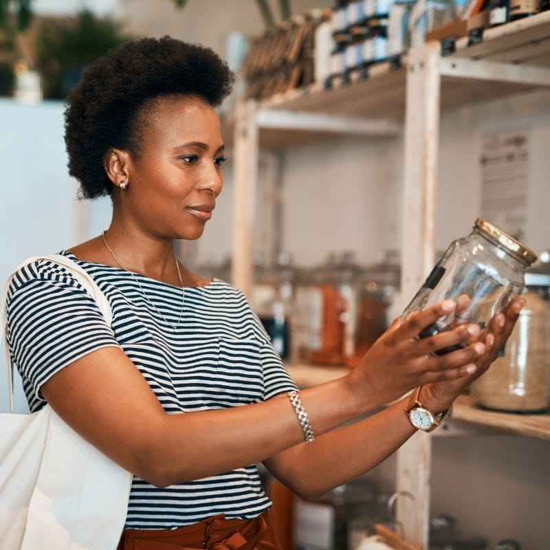 Woman using a glass jar instead of single-use plastics.