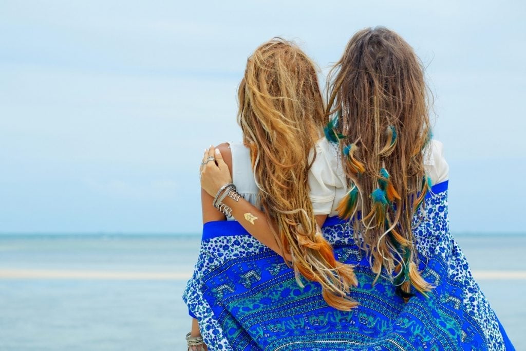 Women looking out at the ocean. Some signs of a wild woman are that they embrace the spontaneous.