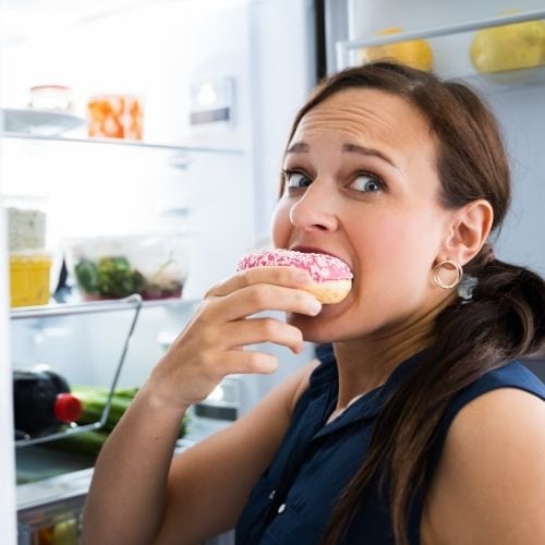 Breastfeeding is hard work on your body, and it might want extra quick sugar, like this woman who is eating donuts. This could be a reason why you're not losing weight while breastfeeding
