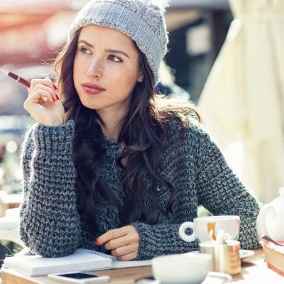 Woman brainstorming ideas in her journal and choosing a word.