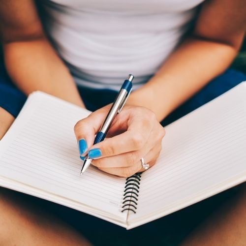 Woman journaling answering questions about her inner dialogue