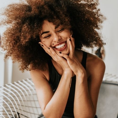 Woman practicing smiling with her affirmations for joy