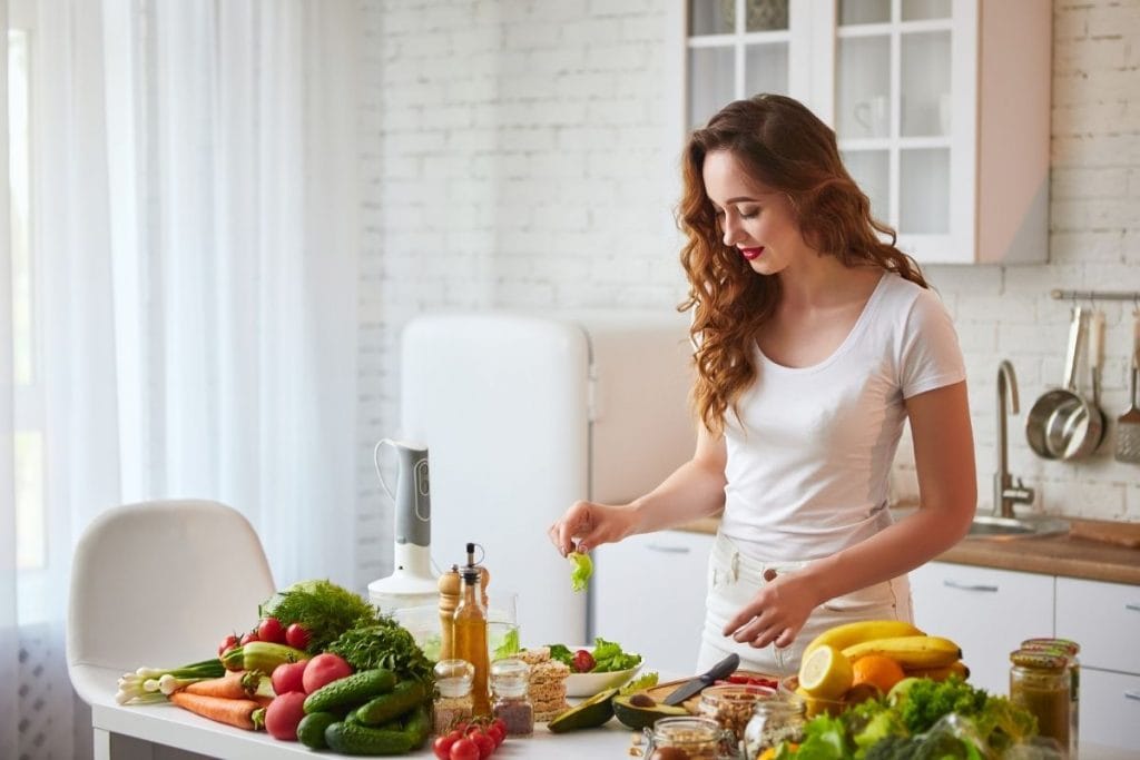 Woman in kitchen preparing a healthy meal knows how to nourish your body