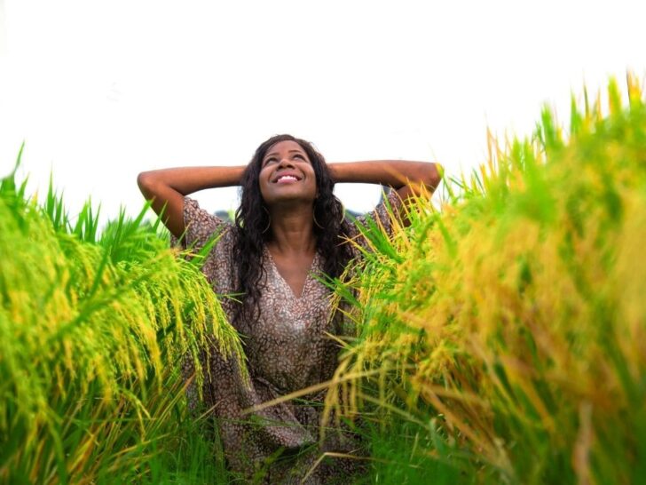 Woman practicing affirmations for acceptance and flow in a field