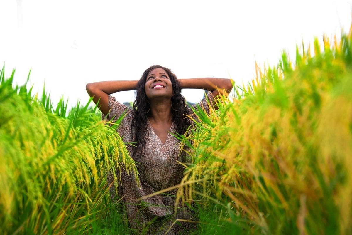 Woman practicing affirmations for acceptance and flow in a field