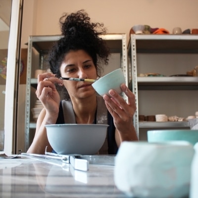 Woman being creative while painting pottery