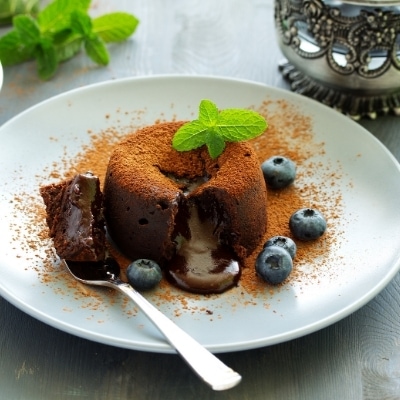 Chocolate Lava cake with blueberries on a white plate.