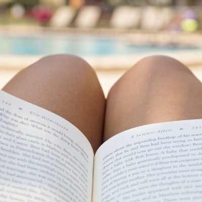 Woman reading outside at the pool