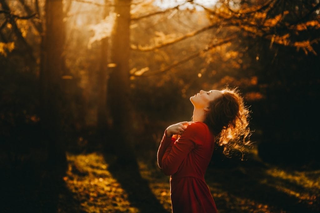 Wild Woman standing in the forest practicing affirmations