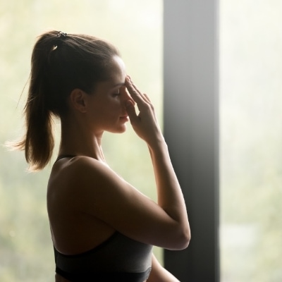 Woman doing alternate nostril breathing, which is a great way to practice the art of doing nothing