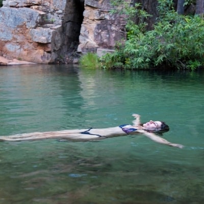 Woman floating with the current is practicing going with the ebbs and flows of life