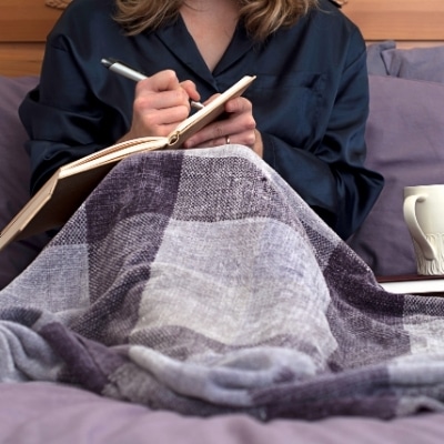 Woman journaling in bed