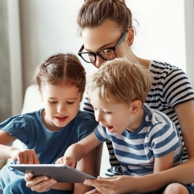 Woman playing with her kids after work and putting all her attention on them