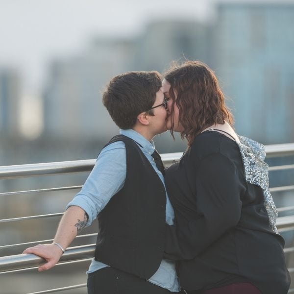 Couple kissing on a bridge.