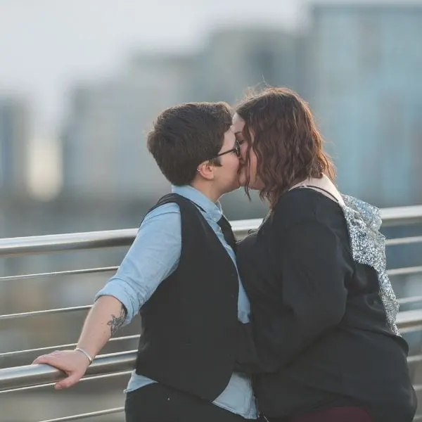 Couple kissing on a bridge.