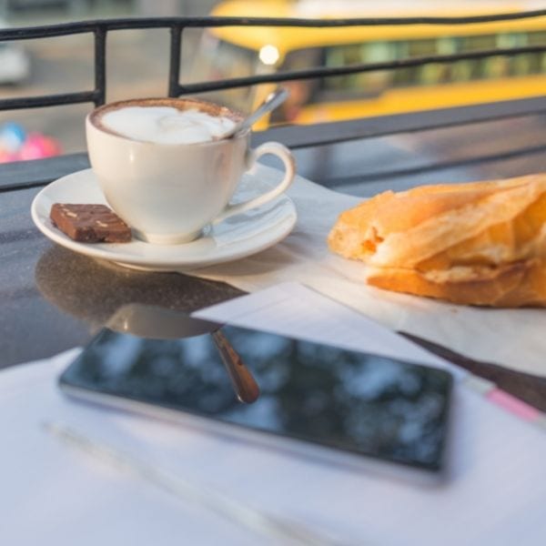 Phone sitting by a cappuccino on a table