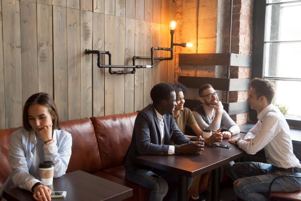 Why do I feel like an outsider. Woman isolated from group at a restaurant