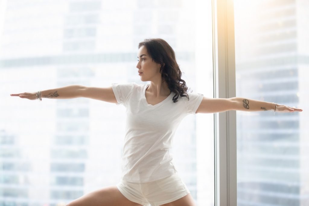 Woman doing yoga is a great way to implement a healthy morning routine