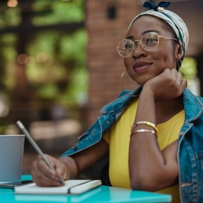 Woman writing in a journal about how she can feel successful after failure