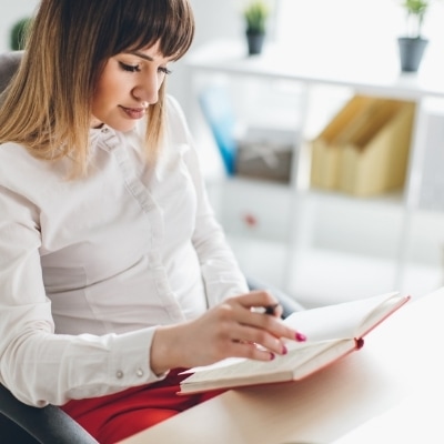 Successful, smart woman reading, realizes that holding onto an outcome does not guarantee happiness