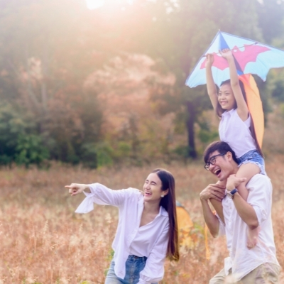Young family taking a trip and flying a kite