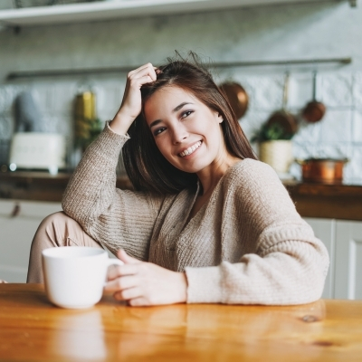 Woman drinking cup of Rasa in her home