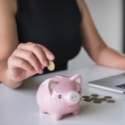 Woman putting coins in a piggy bank