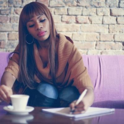 Woman writing in a journal about her successes and accomplishments