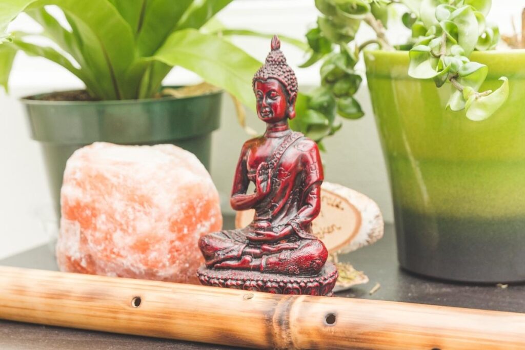 Buddha, flute, and house plants on a sunny shrine