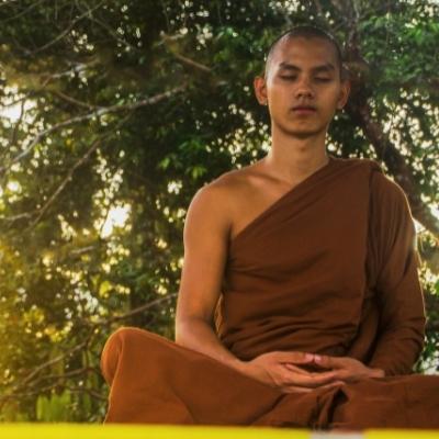 Buddhist monk practicing seated meditation with a relaxed dhyani mudra