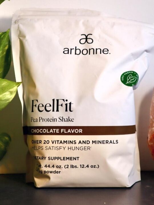 Styled photoshoot of bag of Arbonne Feel Fit Pea Protein Shake Chocolate Flavor